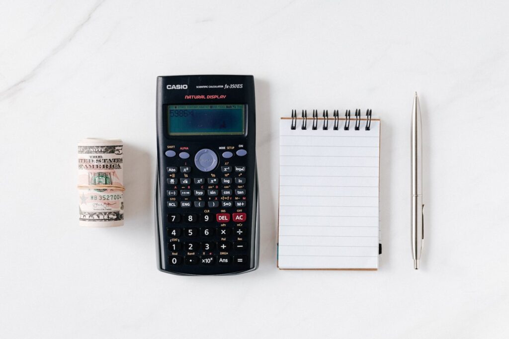 composition of calculator with paper money and notebook with pen to plan a  budget