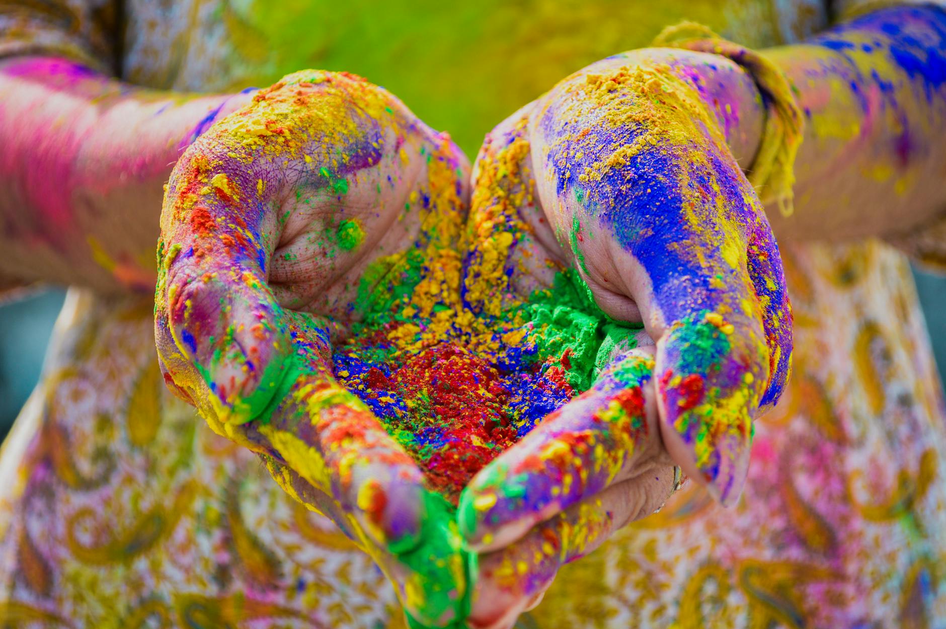 person s hand full of organic colored powder